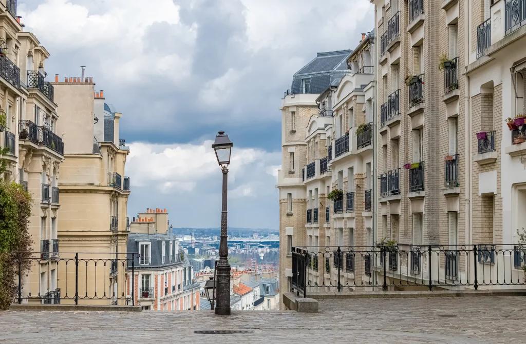 Montmartre street view, Paris, with classic buildings. Partners and financeurs may appreciate this iconic Parisian scene.