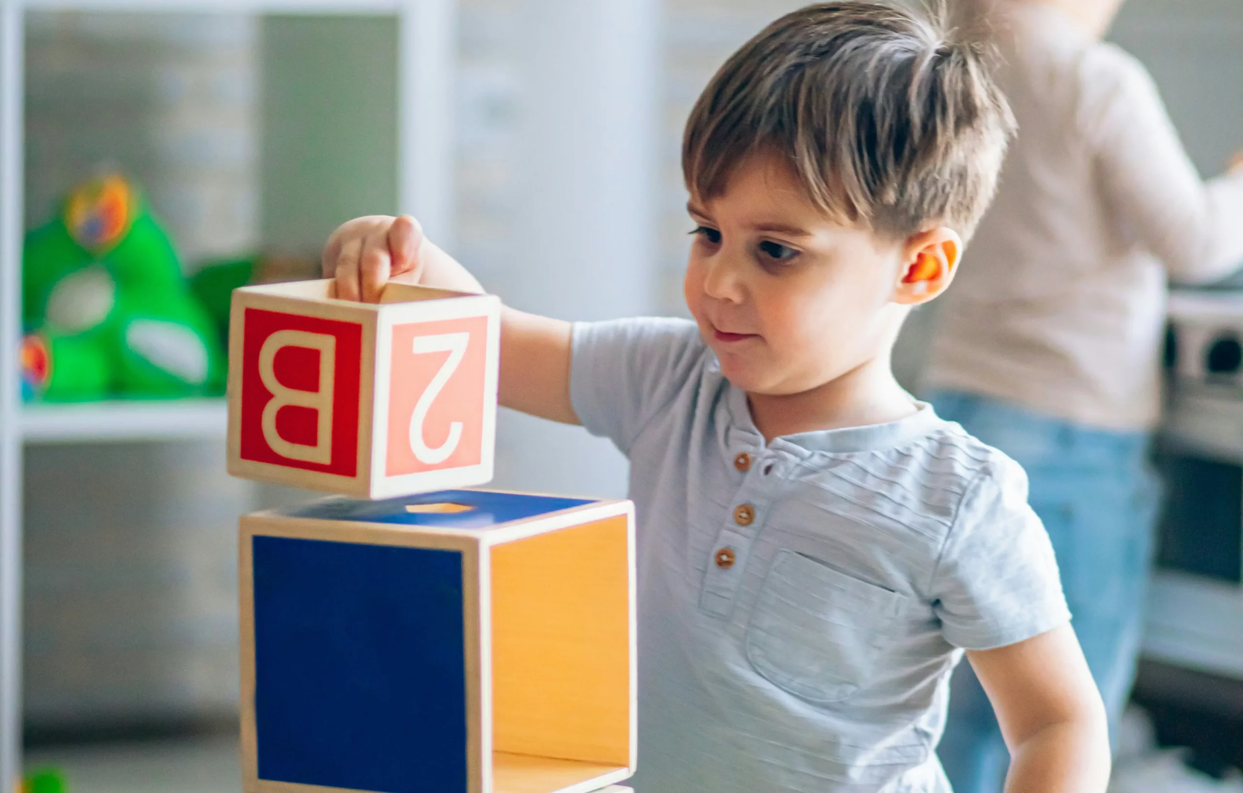 Toddler stacking blocks, playing at Fa Sol Vie creche familiale.